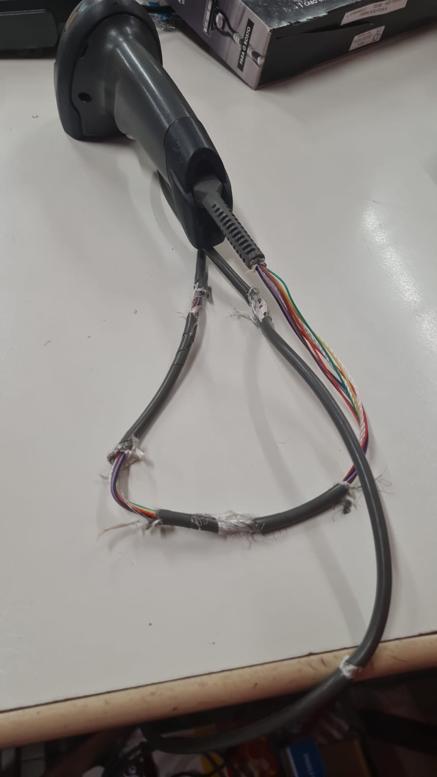 Scanner de código de barras com cabo danificado e várias emendas